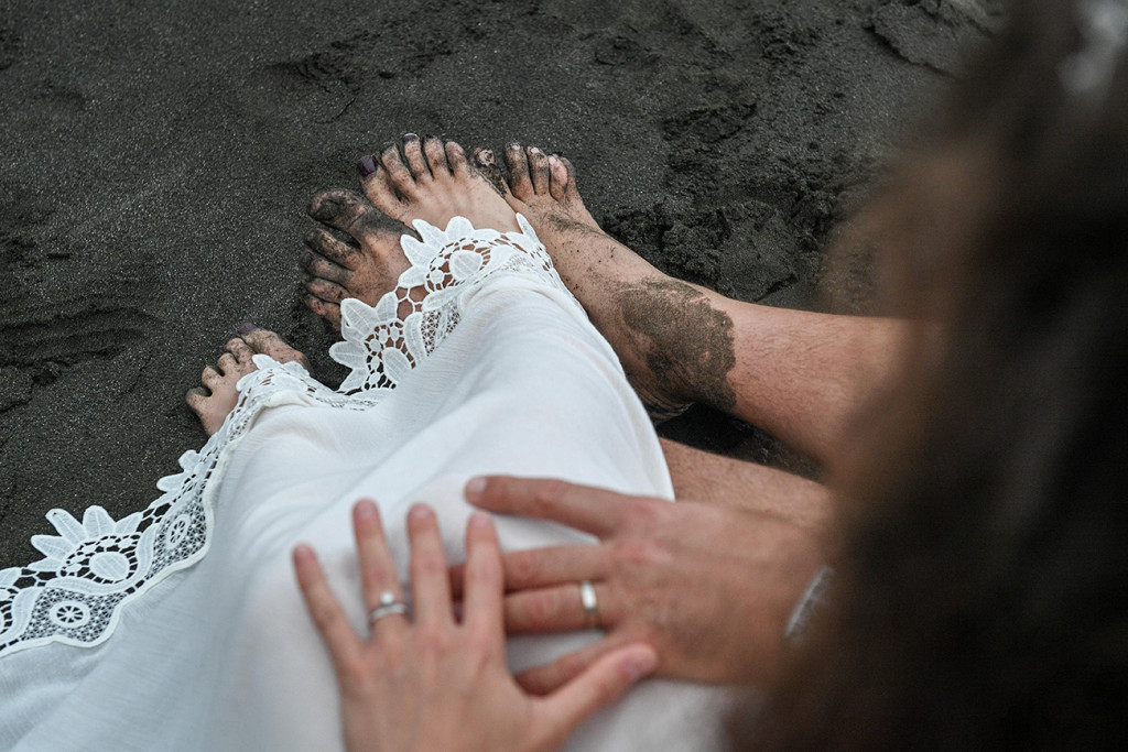 Newly eloped couple show rings and muddy feet at Karekare Beach Auckland NZ