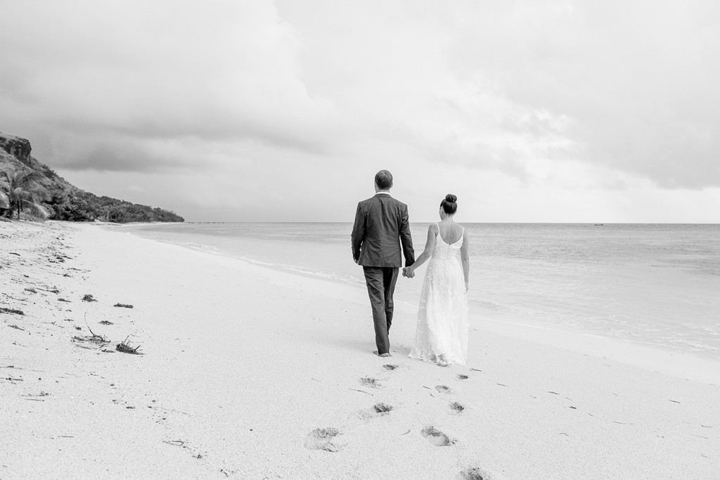 Black and white photo of couple walking down Vomo Island Resort Fiji beach