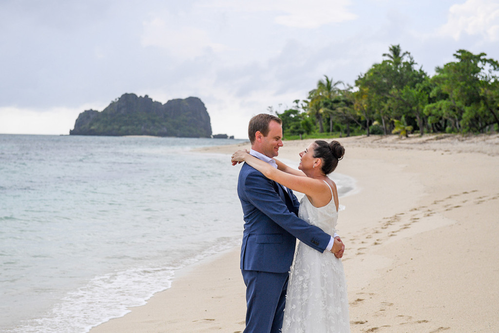 Couple hugs by the beach at the Vomo Island Resort Fiji wedding