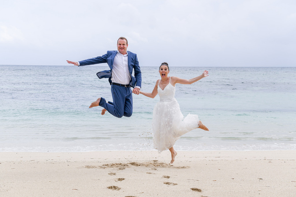 Couple happy jumps on the beach at Vomo Island Resort Fiji wedding