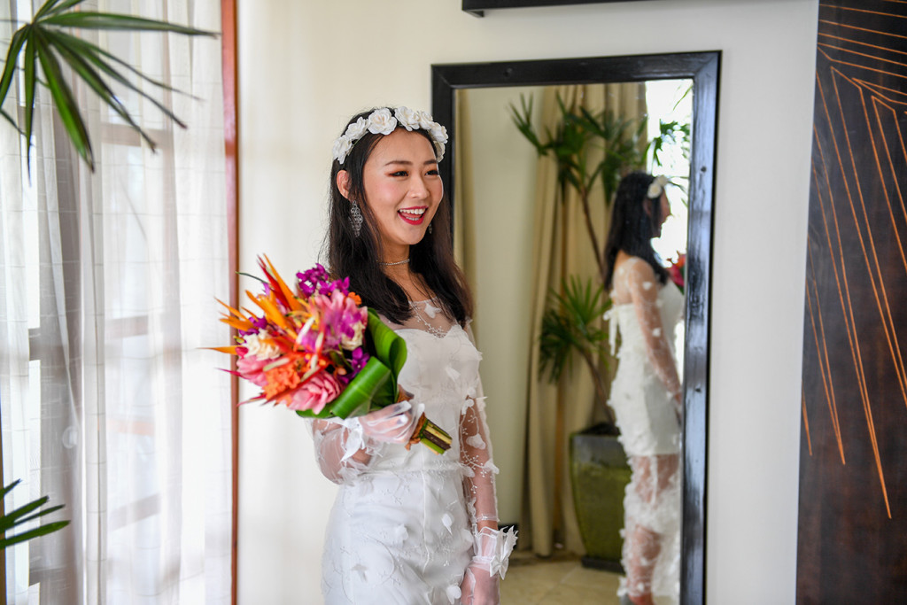 Stunning asian girl holds pink and orange bouqet in Warwick Fiji wedding