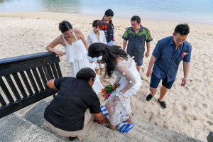 Bride walks on beach towel as she goes up steps on beach in Warwick Fiji wedding