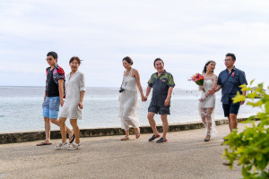 Wedding guests walk along Warwick beach in asian Fiji wedding
