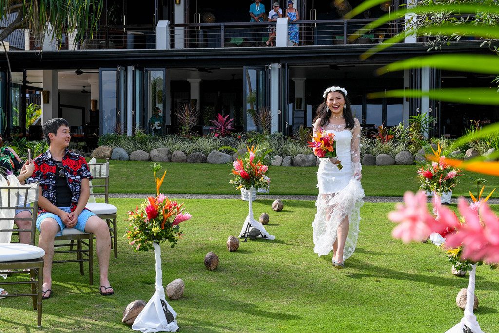 Stunning asian bride holds half see through dress as she walks down the aisle in Warwick Fiji wedding