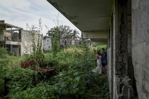 Married couple against abandoned building and overgrow grass in Warwick Fiji photoshoot