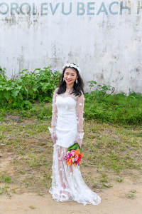 Stunning asian bride poses with her bouquet agains abandoned building in Warwick Fiji