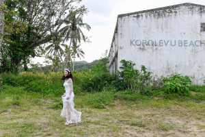 wide shot of bride walking against abandoned building in Warwick Fiji
