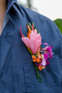 Closeup of groom's pink and orange Fiji floral boutonniere