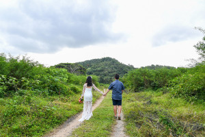 Bride and groom walk into the sunset in wide shot greenery Fiji