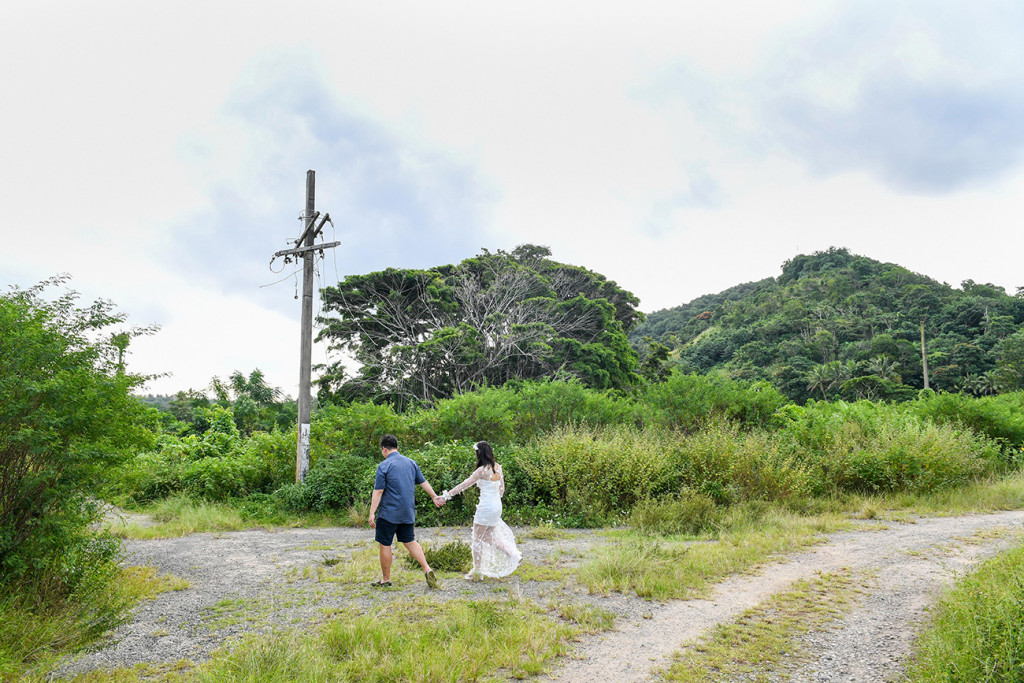 Bride and groom walk into the sunset in wide shot greenery Fiji
