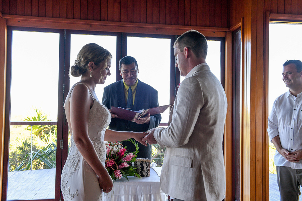 Groom puts ring on bride in The Outrigger