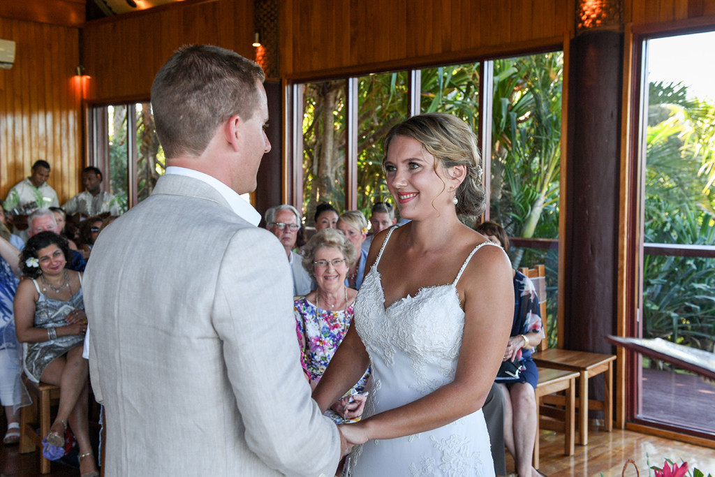 Bride smiles as groom presents vows