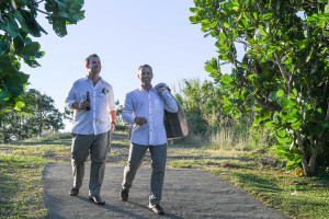 Groom and mate hold coat while strolling on Fiji countryside