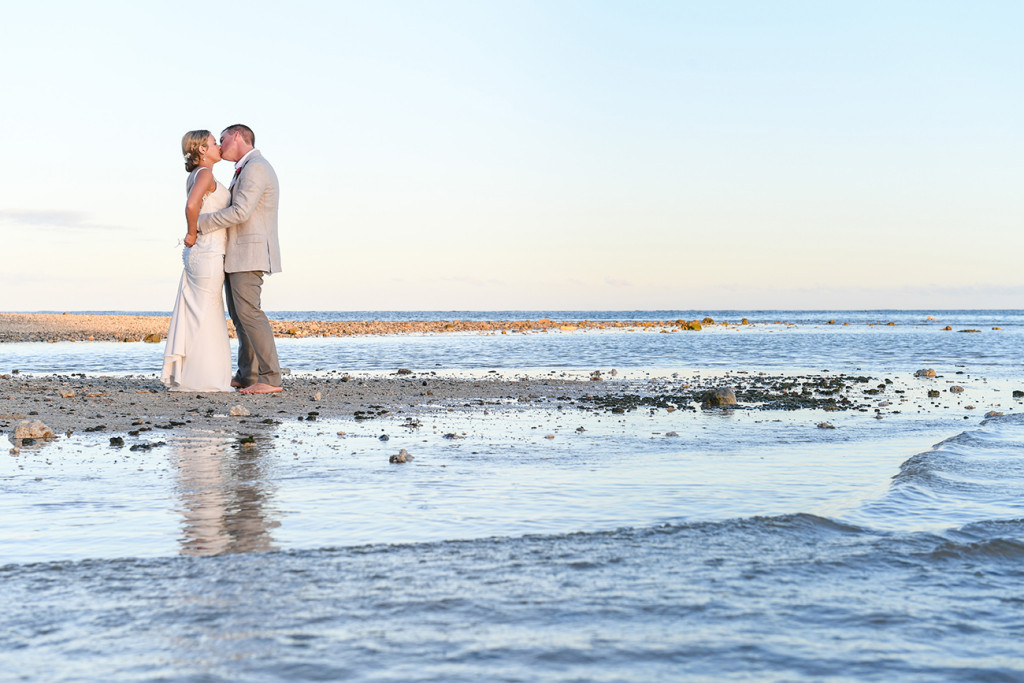 Bride and groom kiss on the sea at Fiji wedding