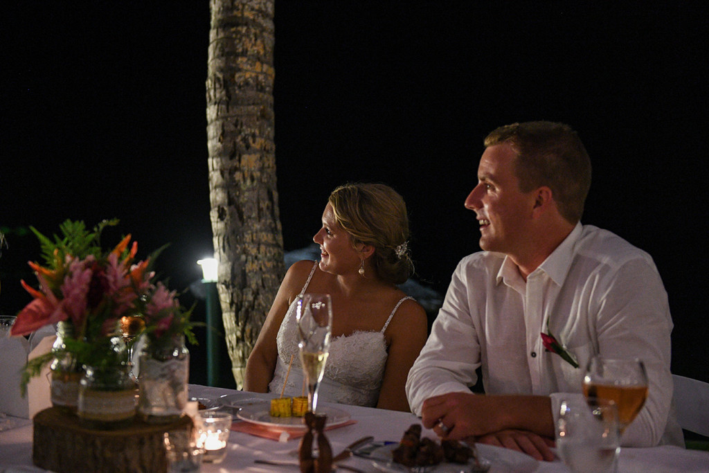 Bride and groom watch speeches in the night at the Outrigger Fiji