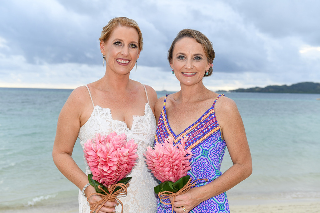 Bride and bridesmaid in bohemian dress and tropical flower bouquet at Plantation Island Resort Fiji