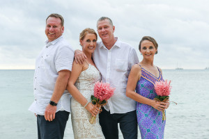 Newly married couple pose with couple of honour against sea in Plantain Island Resort Fiji