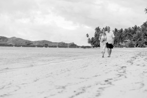Black and white photo of Bride and groom strolling on beach during Plantation Island Resort Wedding