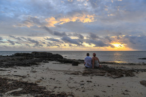 Bride and groom sit and watch the sunset in Fiji Island Resort Wedding