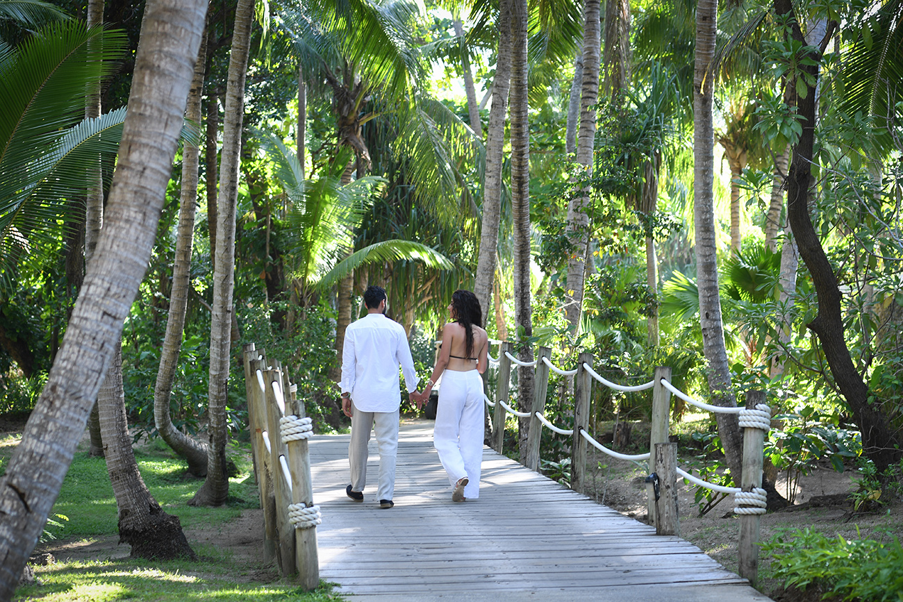 Loving couple walking on wooden bridge in Tropical Likuliku Resort Fiji