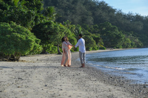 Honeymooning couple play by the ocean at Likuliku Resort