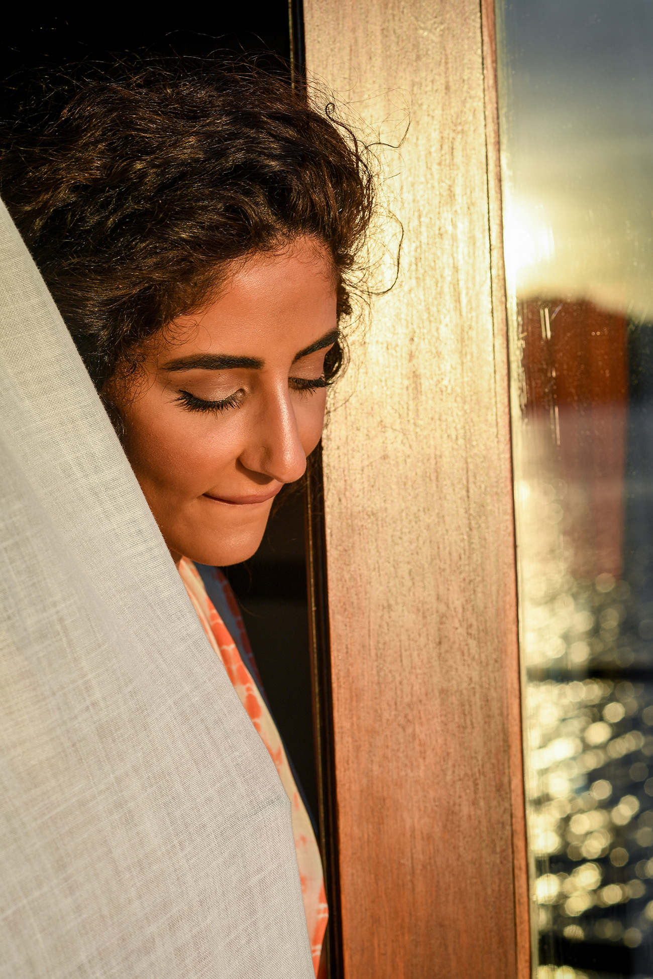 Bride peeps through villa door at sunset in Likuliku Honeymoon