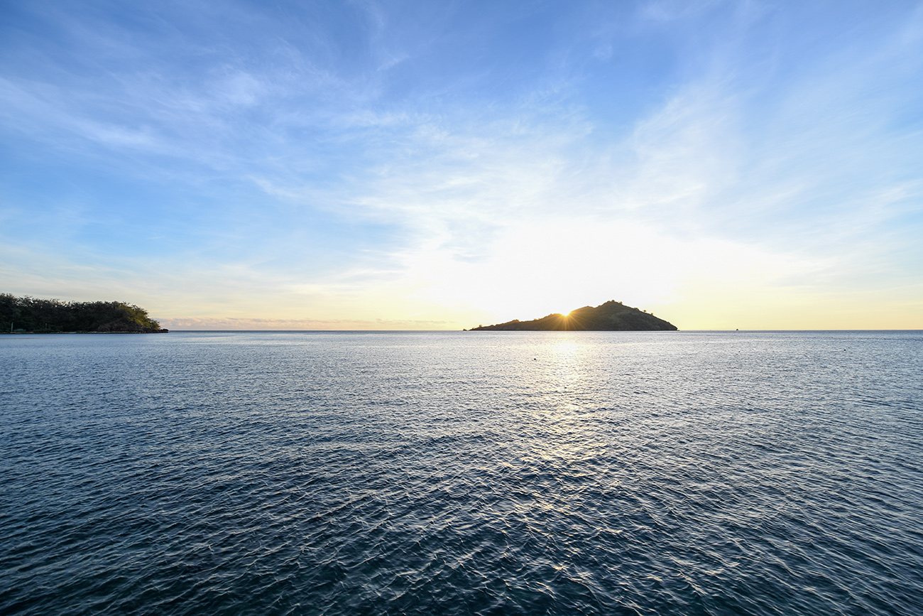 Stunning sunset behind island captured by Anais Chaine Fiji honeymoon photographer