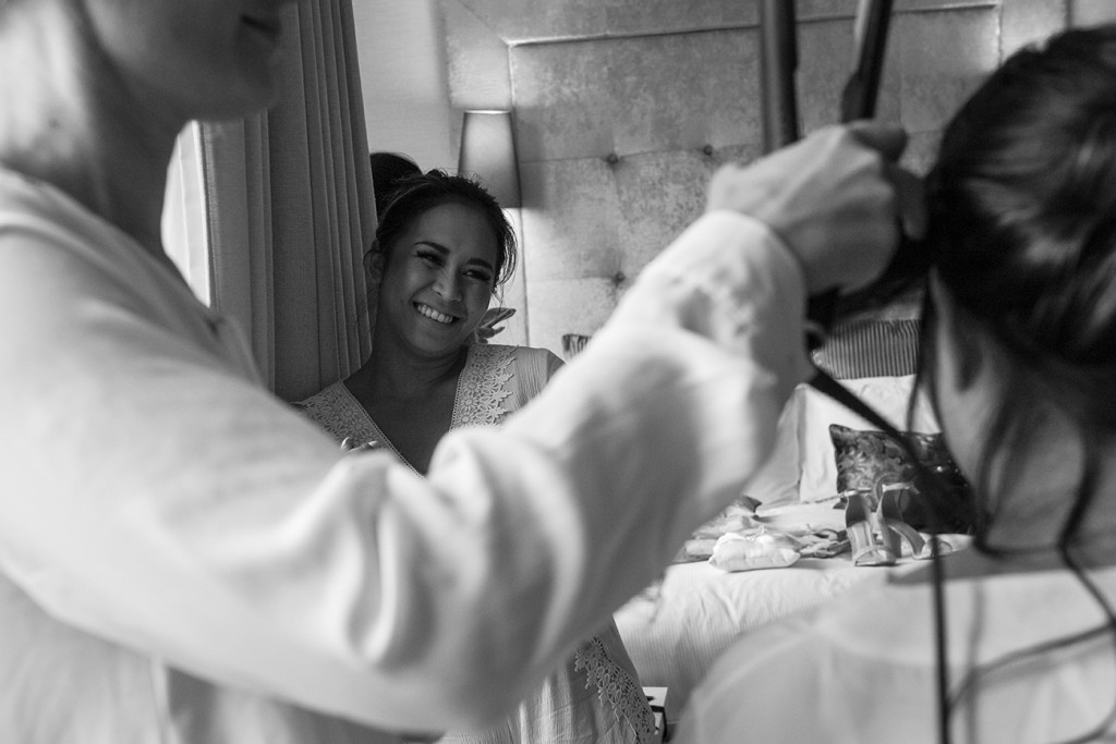 Black and white photo of bridesmaid smiling during wedding preparations