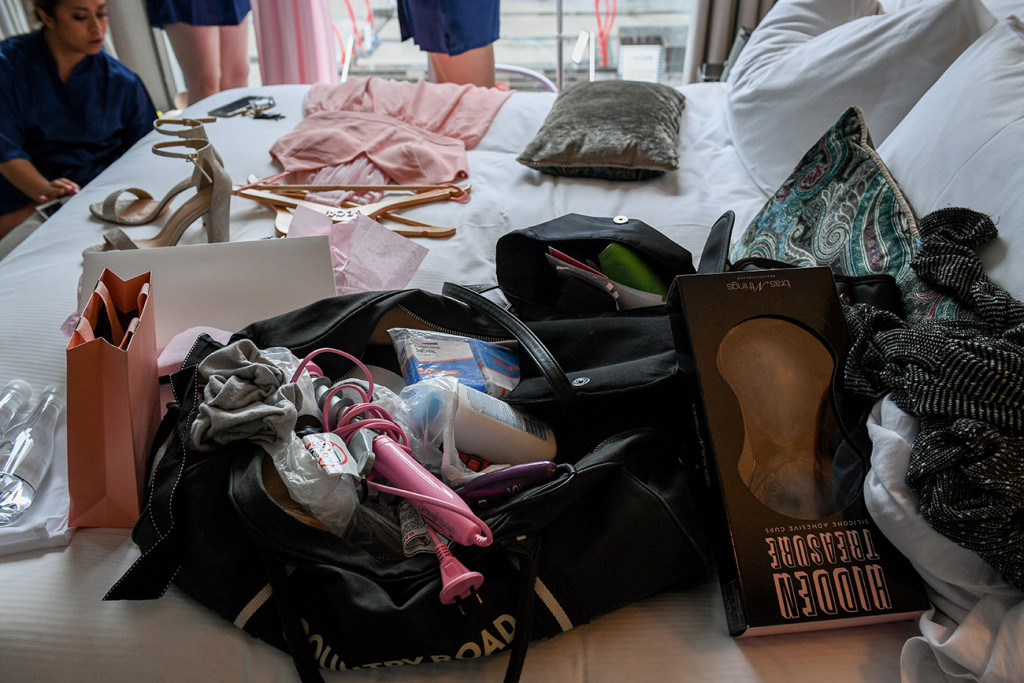 Clothes and shoes strewn on bed during wedding preparation
