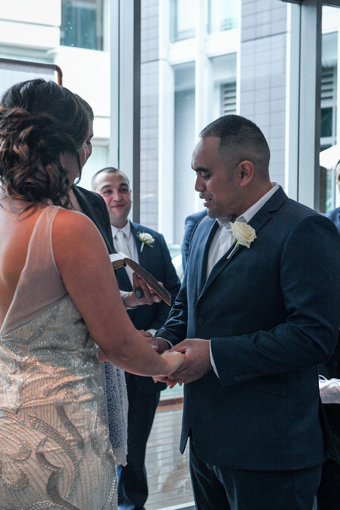 Groom holds brides hands as he says his vows