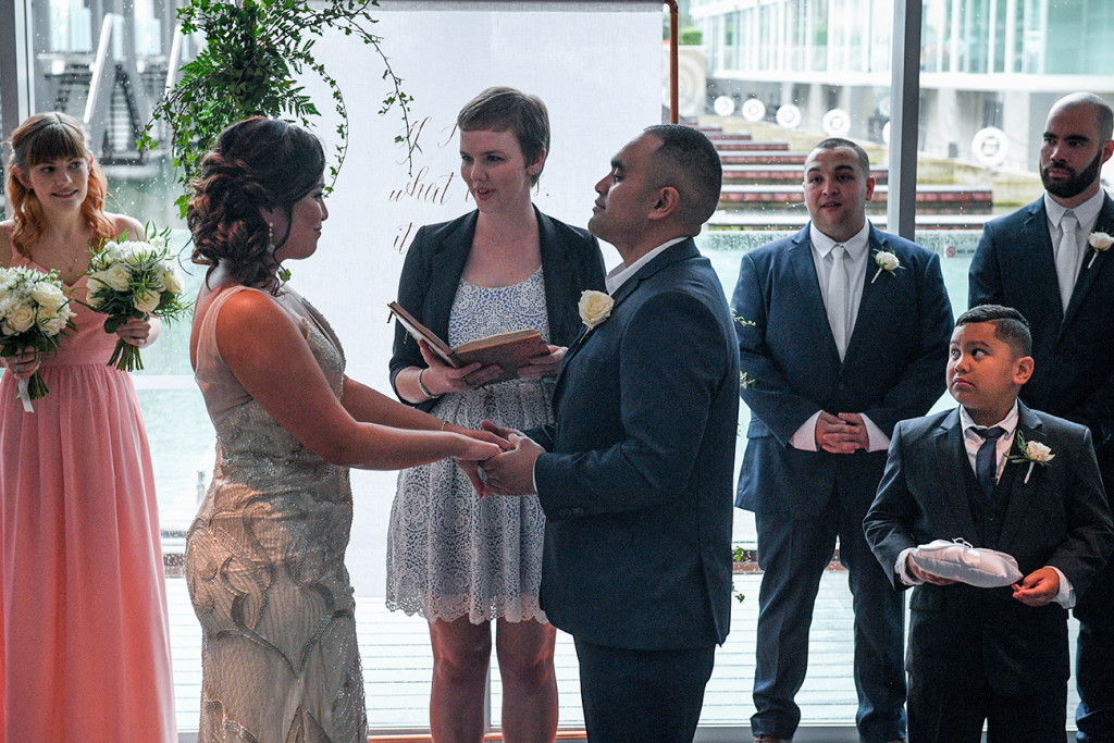 Bride and groom hold hands at the Sofitel Auckland as they exchange vows