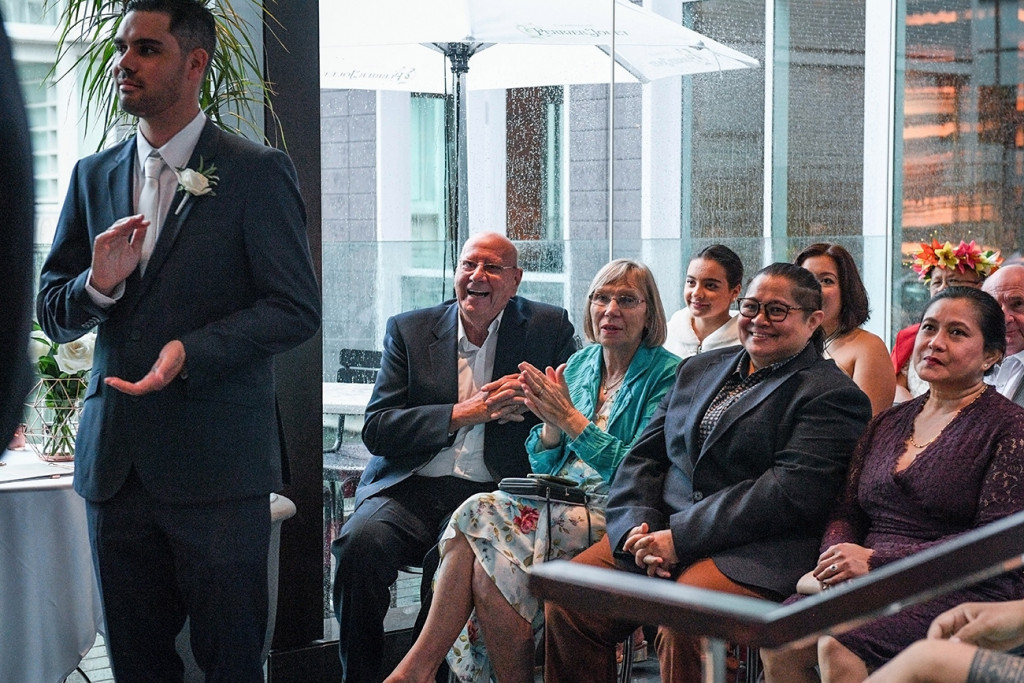 Wedding guests look on as bride and groom exchange vows