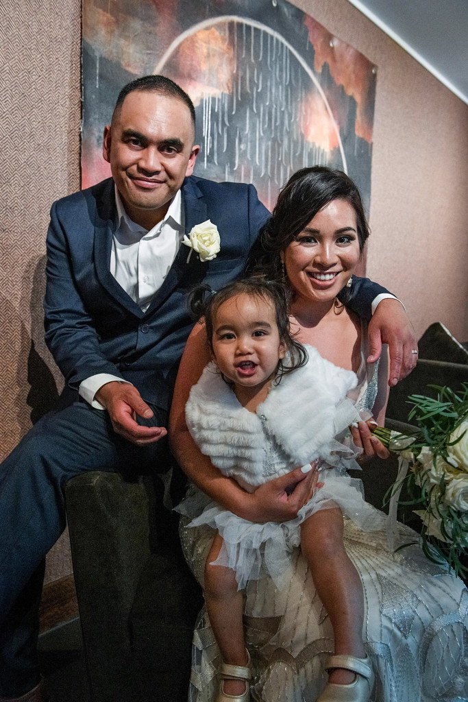 Bride groom and daughter pose for a family portrait