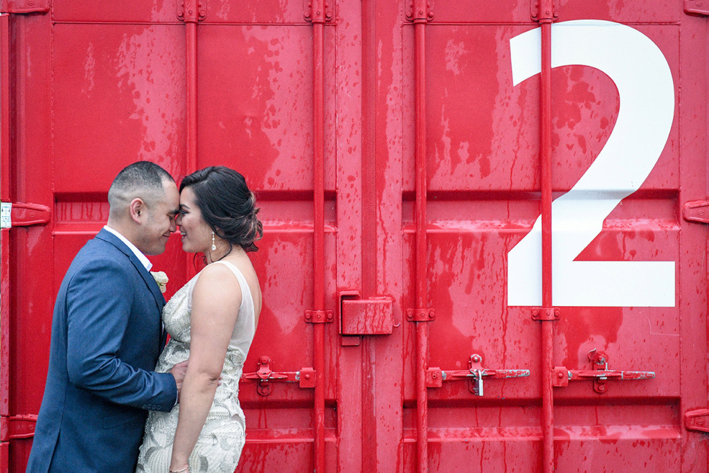 Bride and groom against red container at the Auckland Viaduct