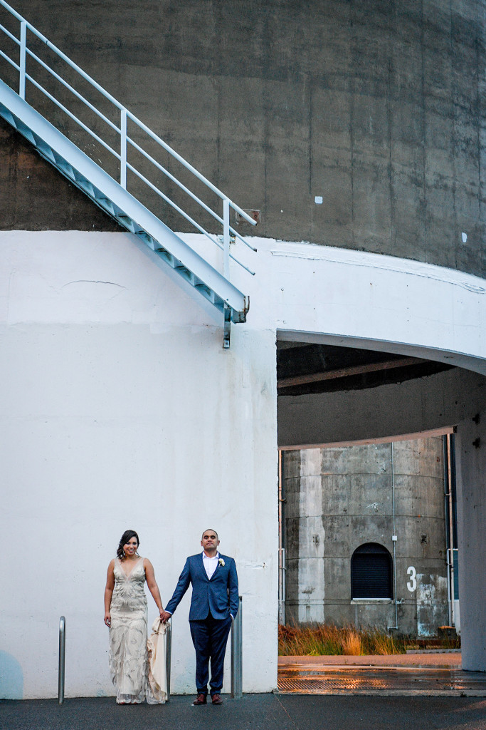 Stunning wideshot of bride and groom against wall in Auckland wedding shoot