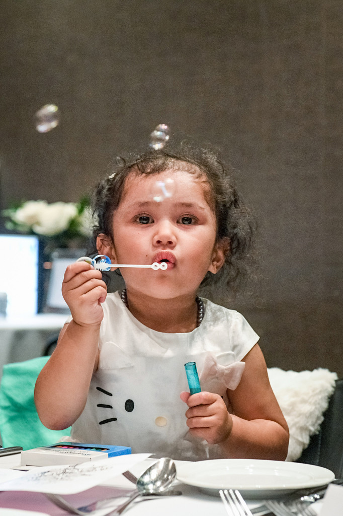 Bride's daughter blows bubbles at the wedding reception