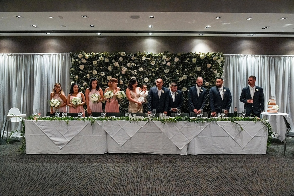 Bridesmaids and groomsmen stand at the reception