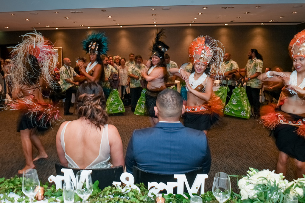Bride and groom watch traditional Polynesian dance