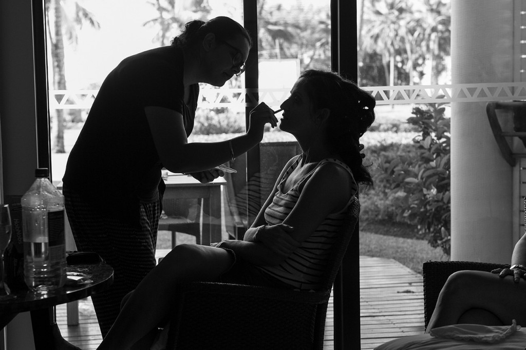 Silhouette photo of bride's make up being touched up.