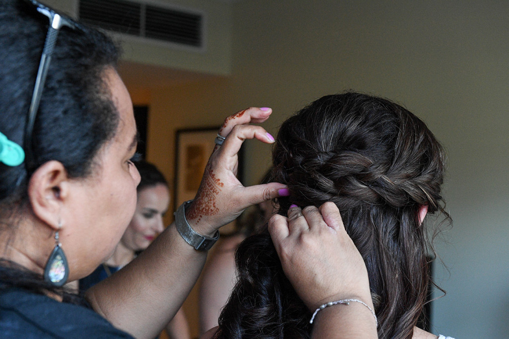Bride's hair being plaited during wedding preparations