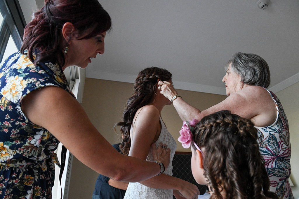 Mom puts hair brooch in brides hair during preparation