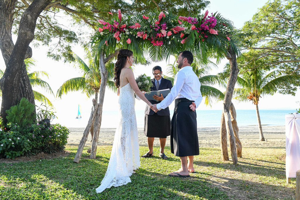 Wideshot of bride and groom saying vows at beachside wedding in Sofitel Fiji