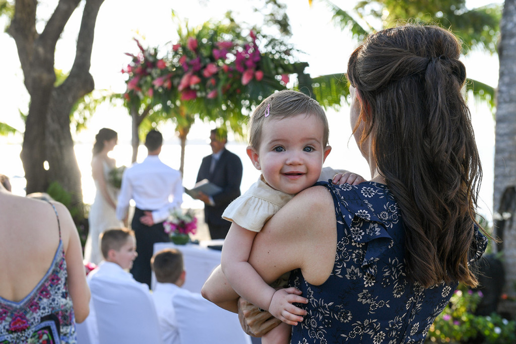 Cute baby smiles at camera in outdoor Fiji Sofitel Wedding