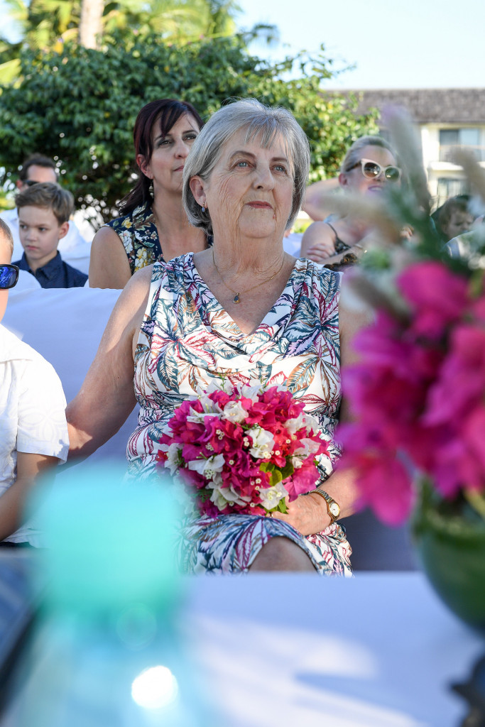 Bride's mom watches couple exchanging vows at the altar