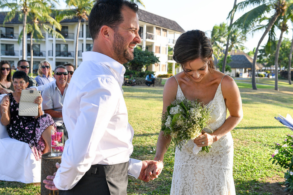 Stunning bride laughs with groom at the altar at beachside wedding Fiji