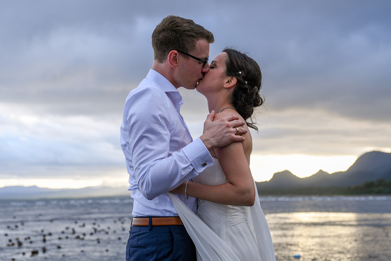 German bride and groom kiss against Fiji PAcific ocean