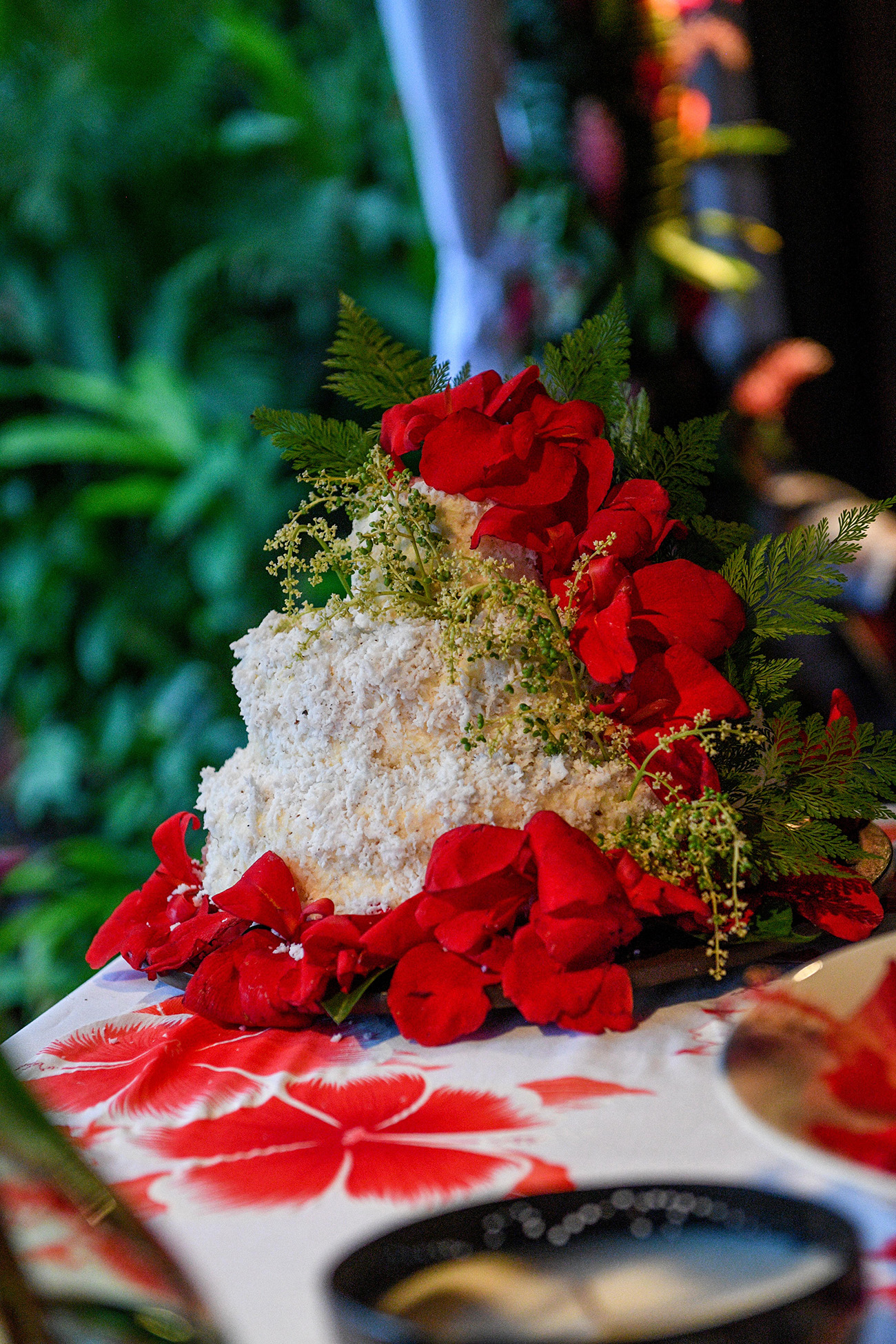 White wedding cake draped with real red Native Fiji flowers