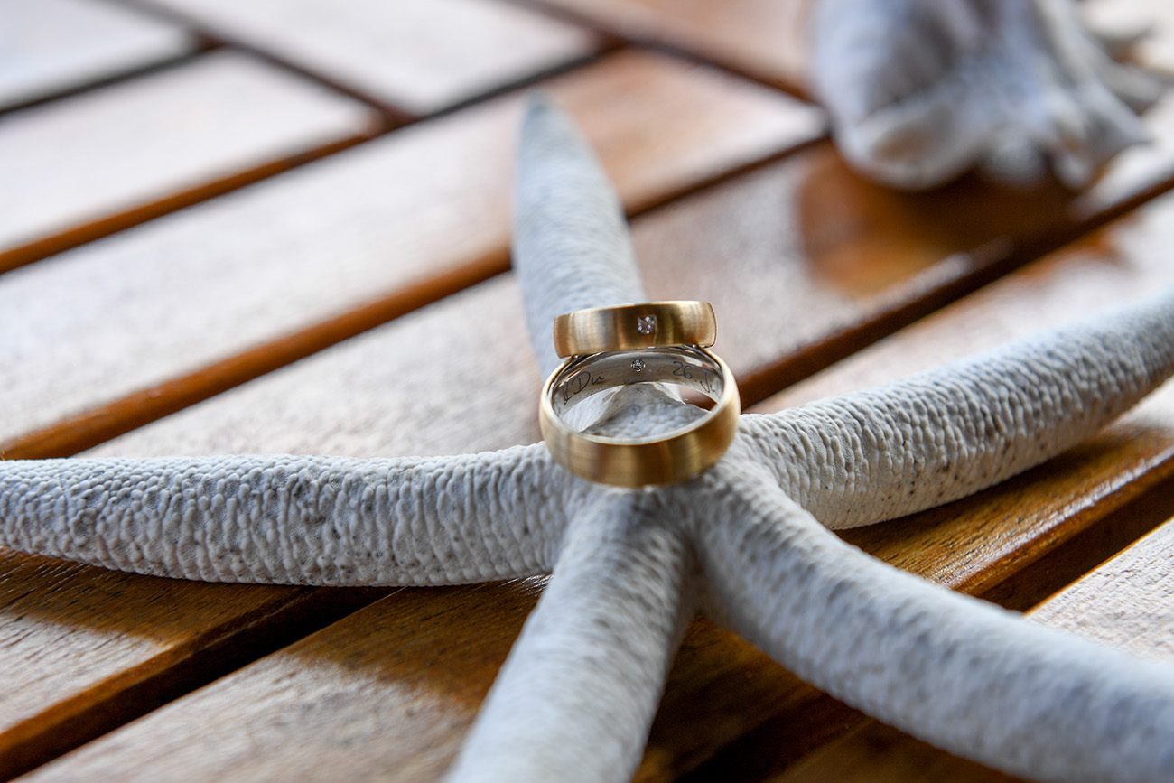 German couple's golden rings ontop of a starfish