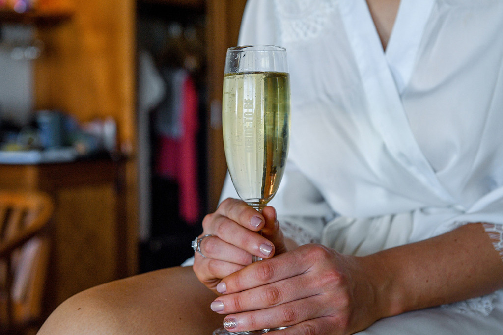 Champagne flute held by bride at boho wedding