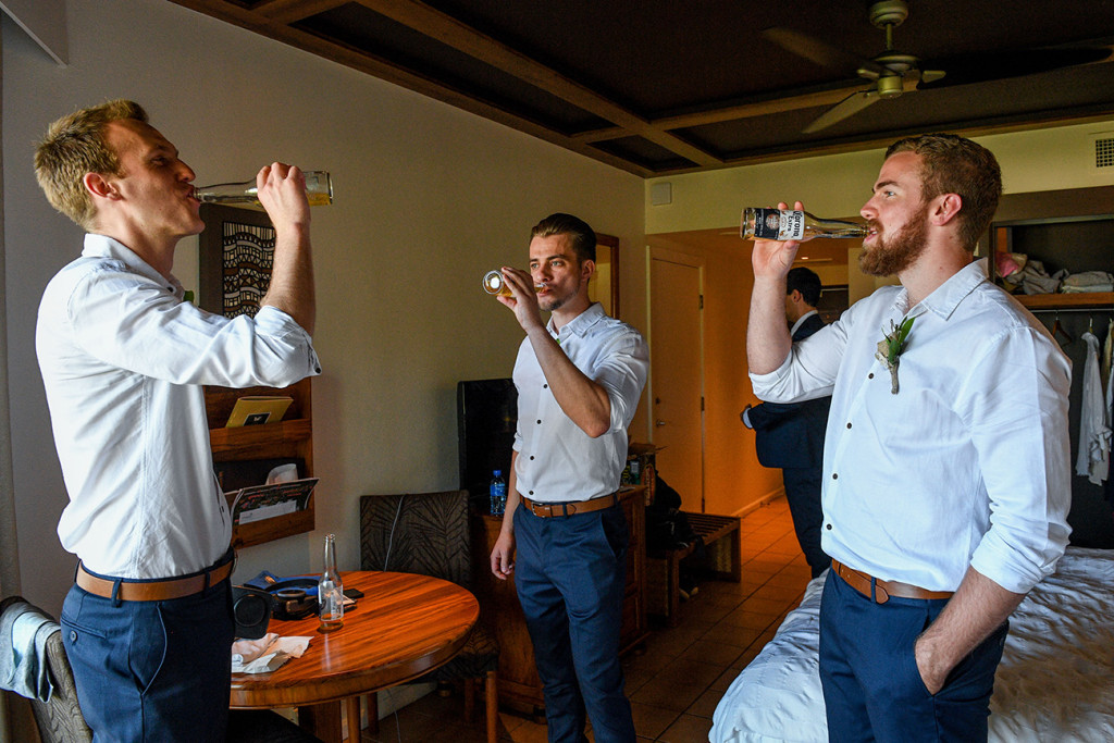 Groom and groomsmen sharing a cheeky beer before the wedding